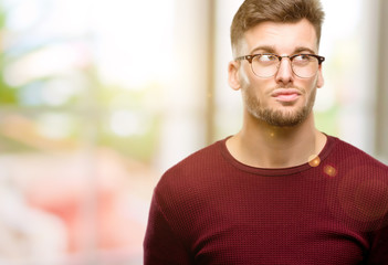 Obraz premium Handsome young man doubt expression, confuse and wonder concept, uncertain future