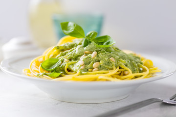 Dish with spaghetti topped with green sauce