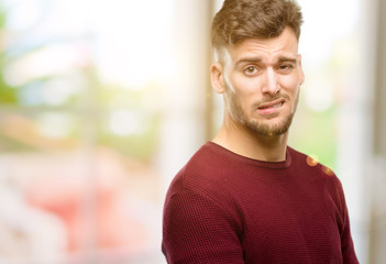 Fototapeta premium Handsome young man doubt expression, confuse and wonder concept, uncertain future