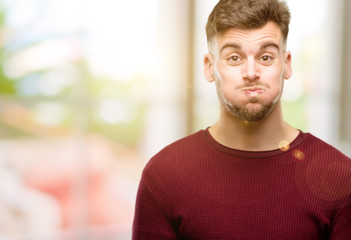 Handsome young man puffing out cheeks, having fun making funny face