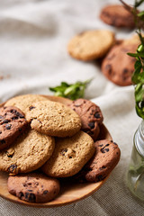 Roasted coffee beans get out of overturned glass jar on homespun tablecloth, selective focus, side view