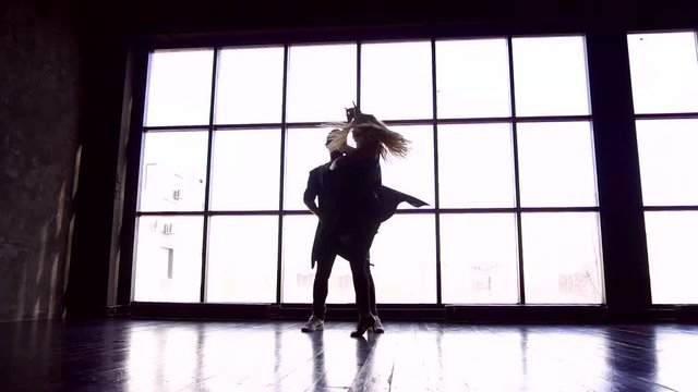 Professional couple of dancers studio. Brazilian zouk. A pair of dancers beautifully dance against the background of a large window closee-up slow motion