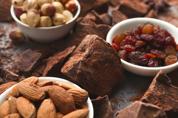 Crushed chocolate bar pieces and cocoa on gray background