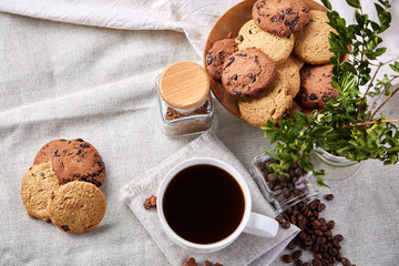 Fototapeta premium Morning coffee in white cup, chocolate chips cookies on cutting board close-up, selective focus