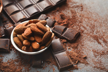 Crushed chocolate bar pieces and cocoa on gray background