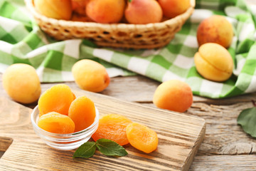 Sweet apricots in bowl on grey wooden table