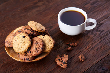 Breakfast background with mug of fresh coffee, homemade oatmeal cookies, grind coffee