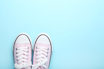 Pair of pink sneakers on blue background