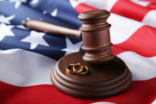 Judge gavel with wedding rings and american flag