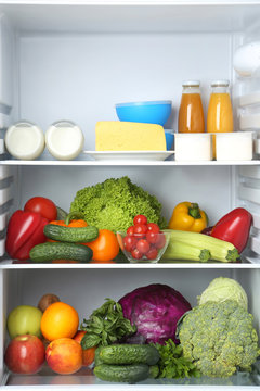 Open fridge full of vegetables and fruits
