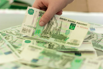 money, Russian thousand bills on the table, children's hand takes the bill in hand