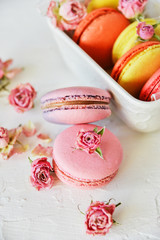 Dessert: A Delicate Fresh Colorful French Macaroons In Pastel Colors Gift Box Flowers Roses On Light Textiles Background