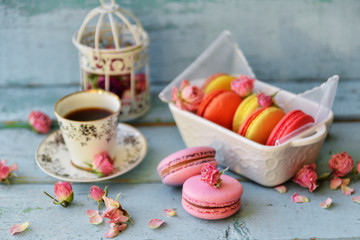 Dessert With Coffee: A Delicate Fresh French Macaroons In Pastel Colors Gift Box Flowers Roses On Light Blue Wooden Background