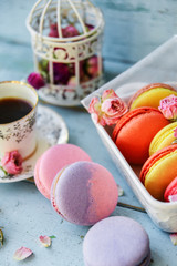 Dessert With Coffee: A Delicate Fresh French Macaroons In Pastel Colors Gift Box Flowers Roses On Light Blue Wooden Background