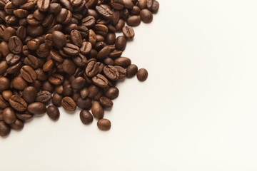 Heap of brown coffee beans isolated on white