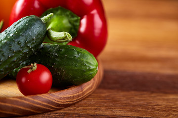 Composition of vegetables on flat plate on wooden table, close-up, selective focus
