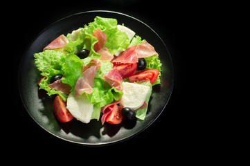 Fresh tasty salad on a glossy black background