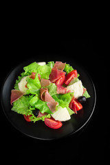 Fresh tasty salad on a glossy black background