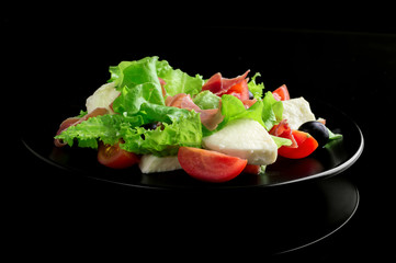 Fresh tasty salad on a glossy black background