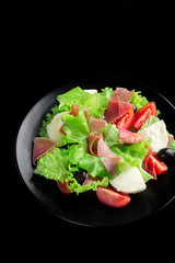 Fresh tasty salad on a glossy black background