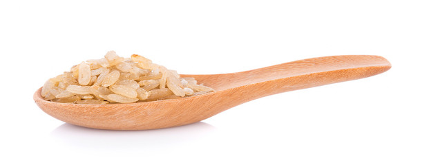 pounded unripe rice in wooden spoon on white background