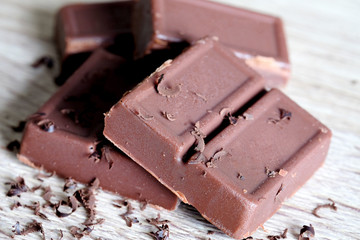 Food snack Dark chocolate cut into pieces on wooden floor.