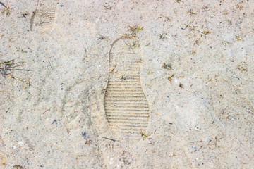 Footprints in the sand. Traces of shoes on sandy shore