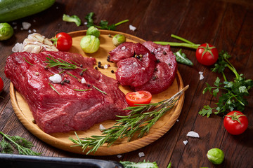 Fresh red radish in wooden bowl among plates with vegetables, herbs and spicies, top view, selective focus.