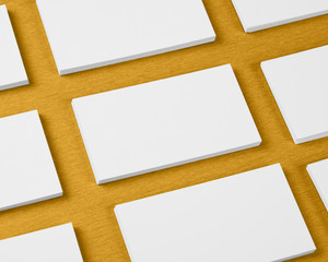 Mockup of horizontal business cards stacks arranged in rows at orange textured background.
