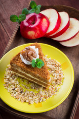 Honey cake on a plate. Wooden rustic background
