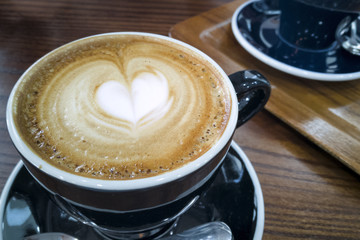 Cappuccino mug close up, with a heart decorated on top of foam
