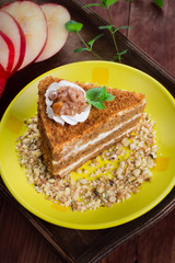 Honey cake on a plate. Wooden rustic background