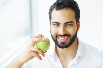 Man Eating Apple. Beautiful Girl With White Teeth Biting Apple. High Resolution Image