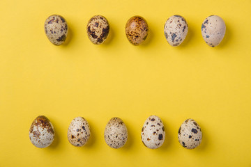 Beautiful spotted fresh quail eggs on a yellow paper background