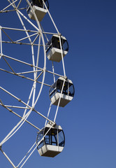 Ferris wheel cabins close-up against the blue sky.
