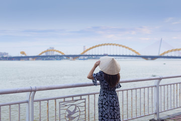 Woman is traveling at Danang, Vietnam with looking at Dragon bridge.