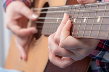 Obraz premium close-up of a young woman's hands playing guitar