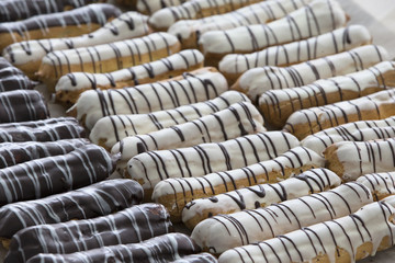 Various eclairs covered with white and chocolate icing