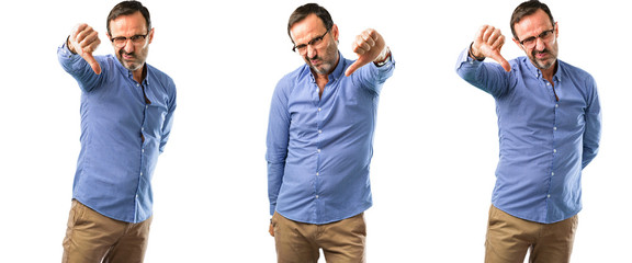 Middle age handsome man showing thumbs down unhappy sign of dislike, negative expression and disapproval over white background