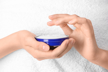 Young woman with jar of hand cream, closeup