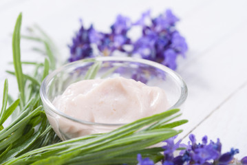 cosmetic cream and lavender flowers on white wood table background