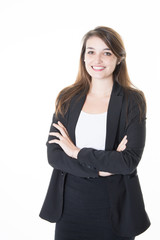 formally dressed business woman looking into the camera with her arms crossed while standing in...