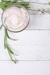 cosmetic cream and lavender flowers on white wood table background