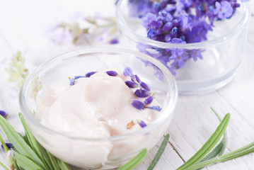 cosmetic cream and lavender flowers on white wood table background