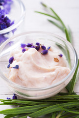 cosmetic cream and lavender flowers on white wood table background