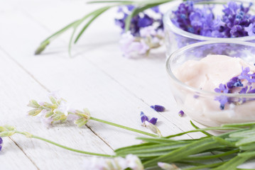 cosmetic cream and lavender flowers on white wood table background