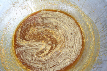 Simmer of honey bee in big pan top view closeup background