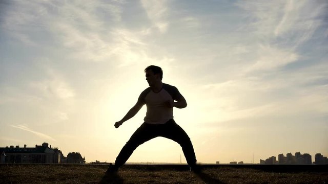 Slow-motion - young male Parkour tricker jumper performs amazing flips in front of the sun