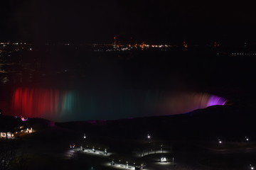 Naklejka na ściany i meble Colorful illuminated Niagara Waterfalls at night in Ontario, Canada