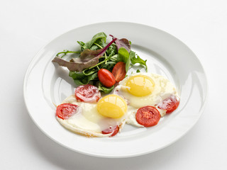 Plate with scrambled eggs and tomatoes